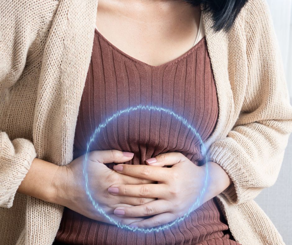 Woman holding her stomach . A blue circle on the stomach indicates where she feels bloated
