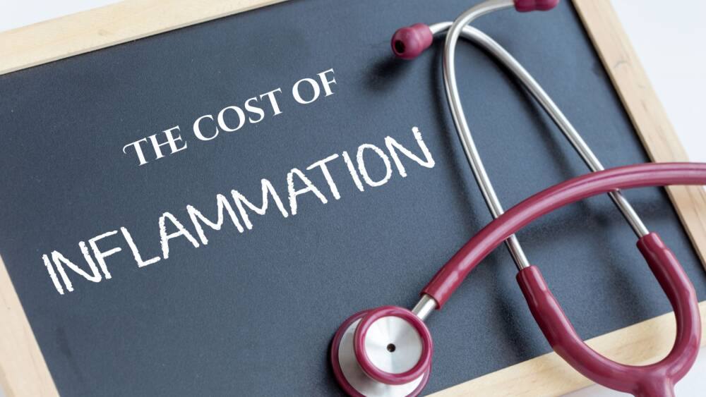Pink stethoscope on a chalkboard displaying the words “The Cost of Inflammation.”